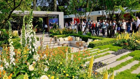 A show garden full of colourful flowers and a seating area at the Chelsea Flower Show