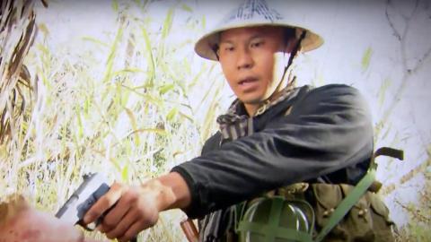 Viet Cong soldier holding a handgun to someone's head